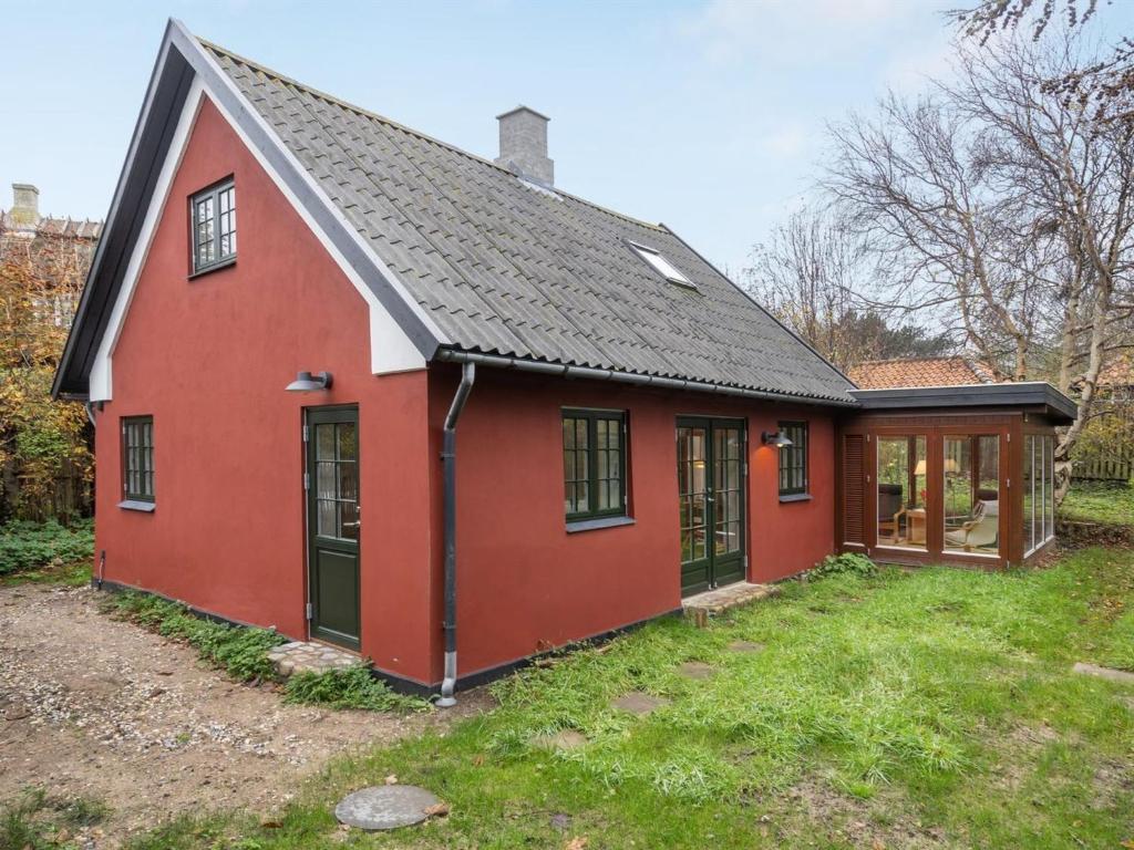 ein rotes Haus mit schwarzem Dach in der Unterkunft Holiday Home Tabetha - 25m from the sea in Sealand by Interhome in Tisvildeleje