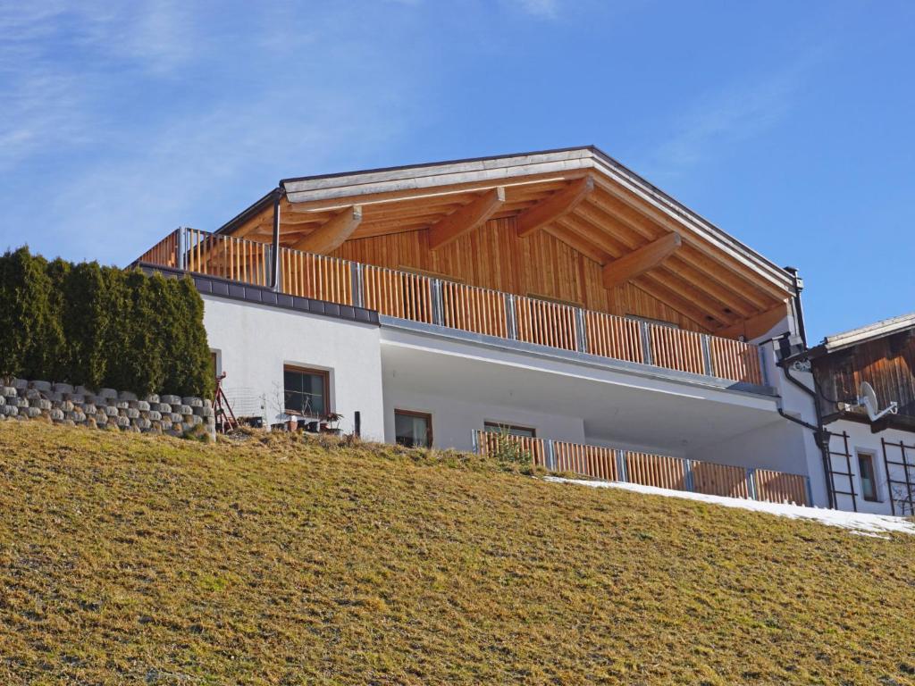 a house with a wooden roof on top of a hill at Apartment Freiheit-La by Interhome in Schnann