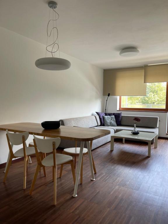 uma sala de estar com uma mesa e um sofá em Apartmán Tera em Čeladná