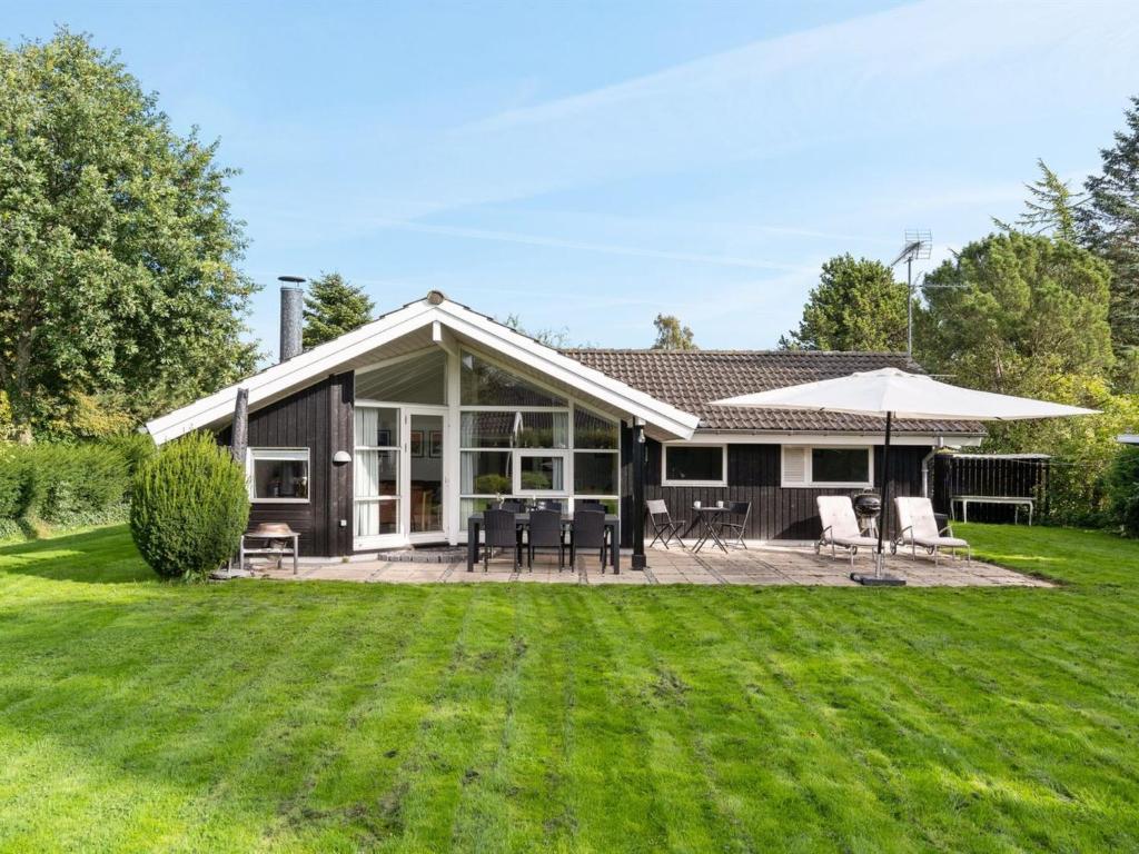 a house with a patio and a lawn at Holiday Home Eivor - 500m from the sea in Sealand by Interhome in Hornbæk