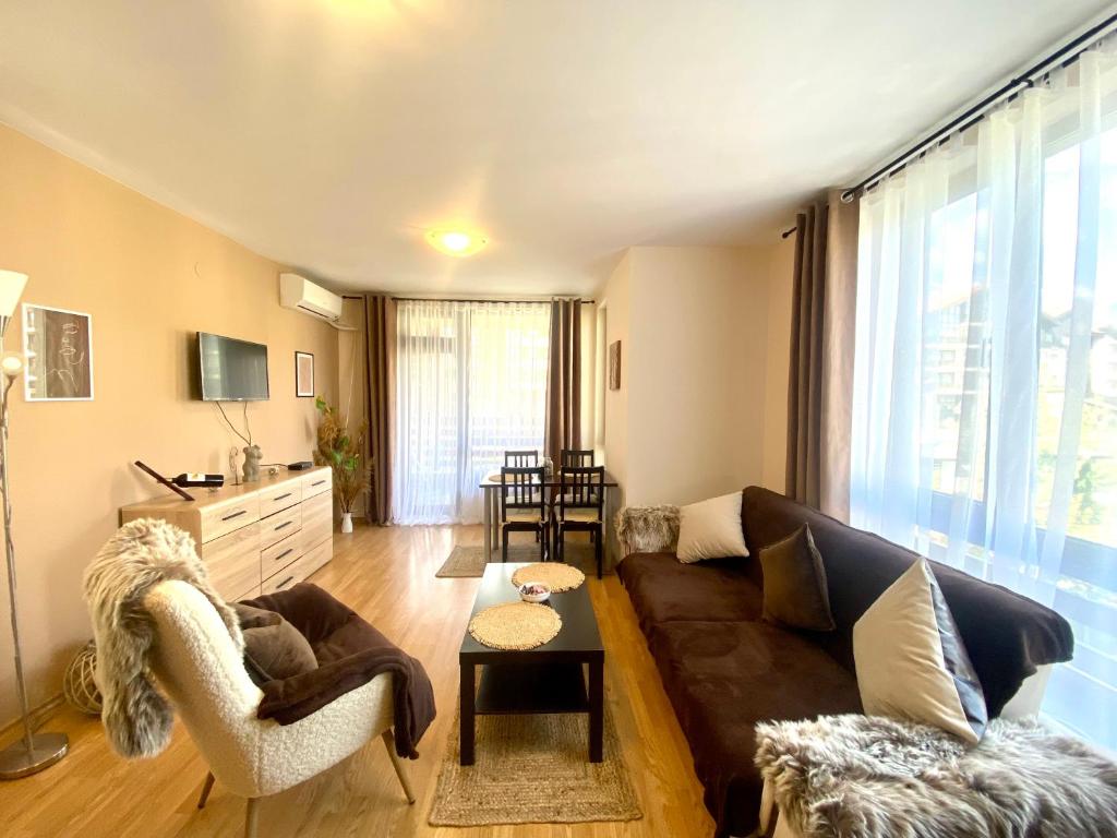 uma sala de estar com um sofá, cadeiras e uma mesa em Aspen Suites Apartments em Bansko