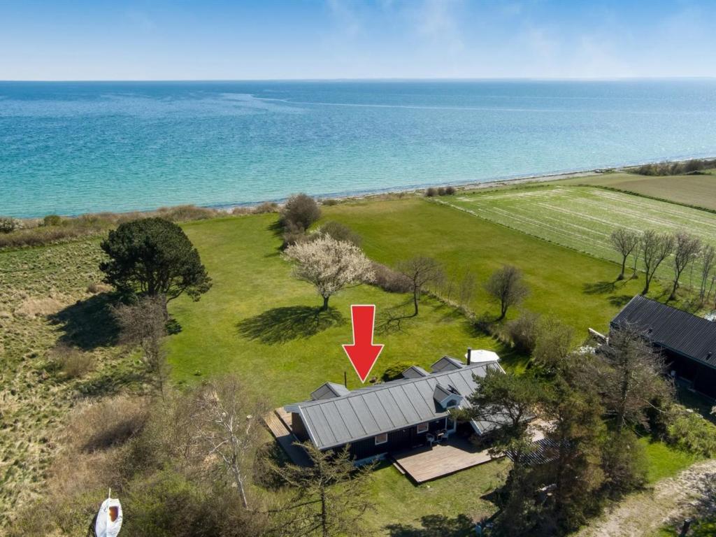 an aerial view of a house in a field next to the ocean at Holiday Home Trajko - 100m from the sea in Sealand by Interhome in Hou