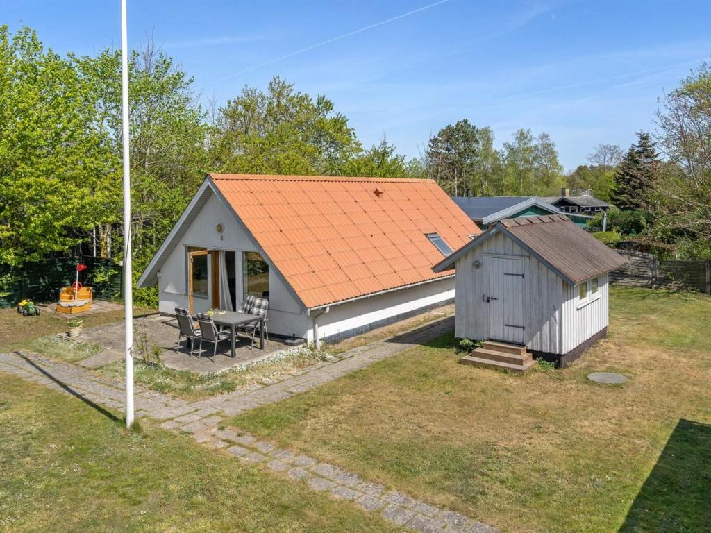 una piccola casa con un tetto arancione in un cortile di Holiday Home Marita - 225m from the sea in Sealand by Interhome a Korsør