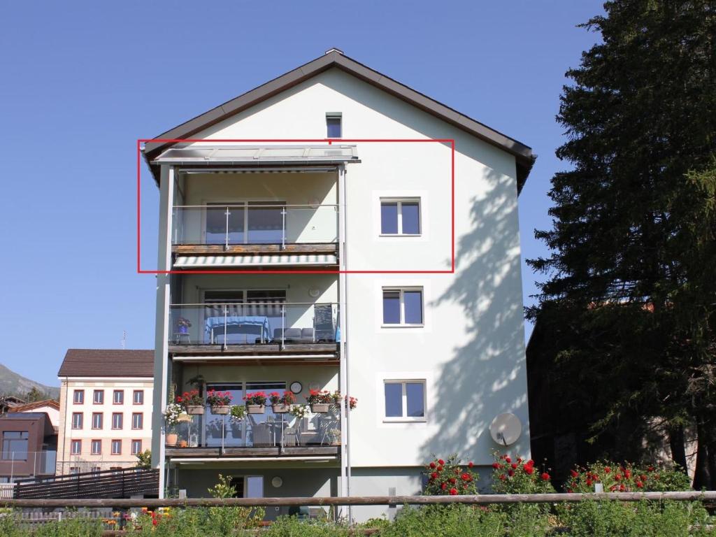 Apartment Pardi 3 Simeon by Interhome في Lenz: مبنى شقق بيضاء مع ورود على البلكونات