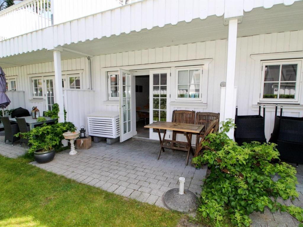 een patio met een tafel en stoelen op een huis bij Apartment Galia - 2km from the sea in Sealand by Interhome in Rørvig