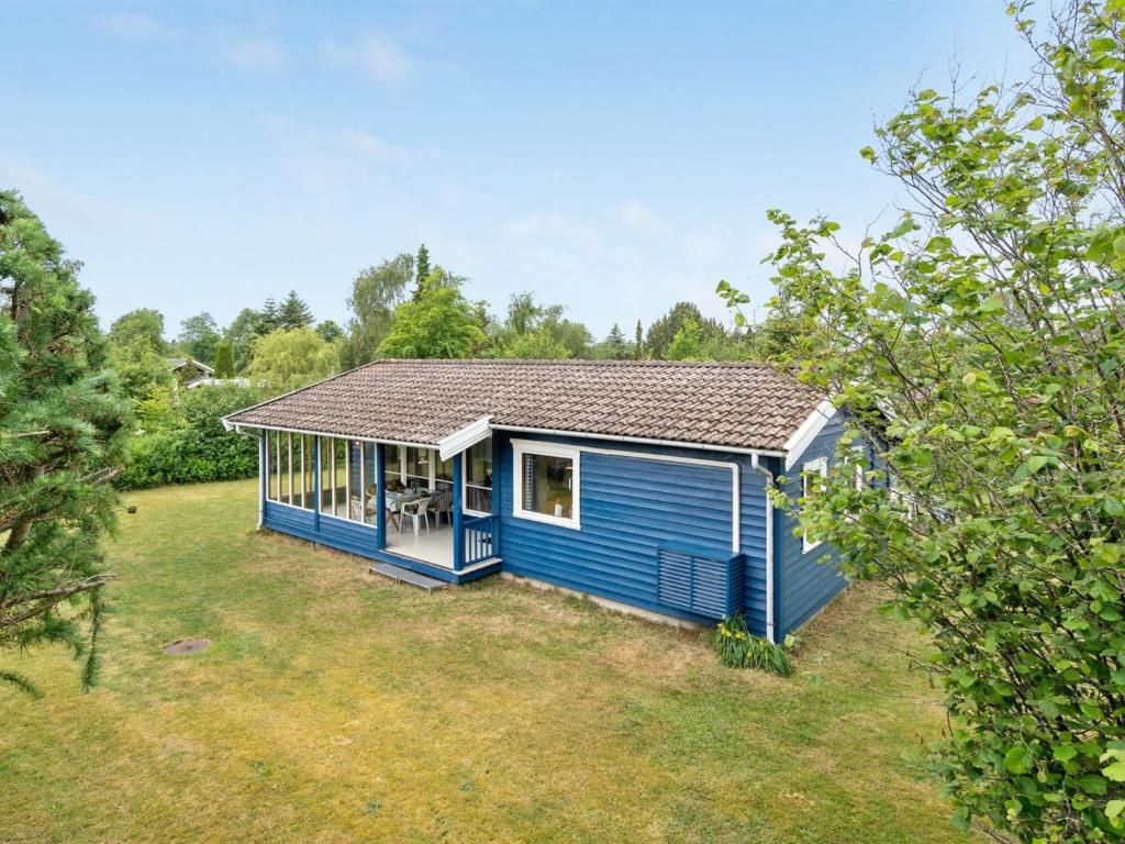 una casita azul en un patio en Holiday Home Holga - 450m from the sea in Sealand by Interhome, en Store Fuglede