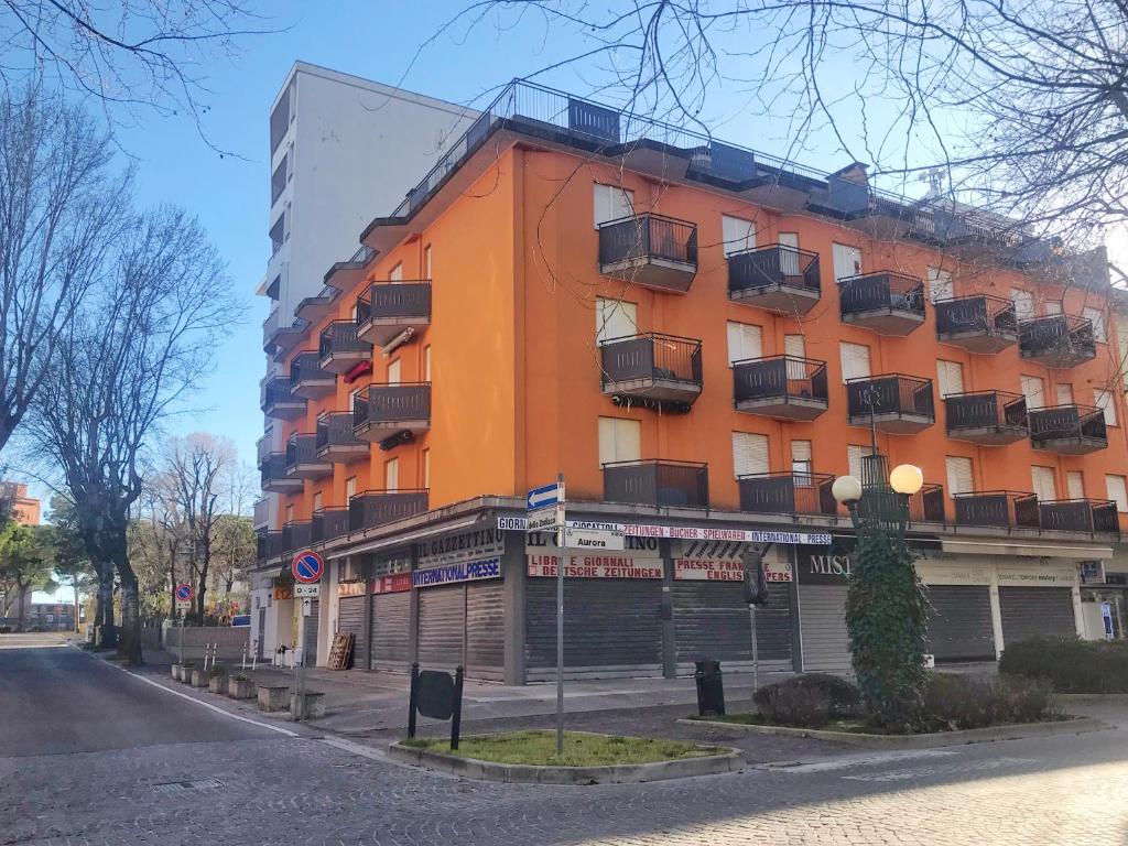 a large orange building with balconies on a street at Condominio Leda in Bibione