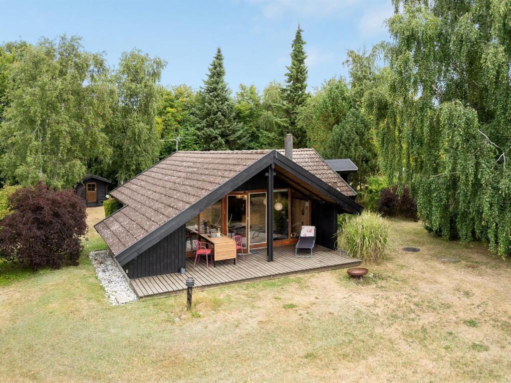 een klein huis met een terras in een tuin bij Holiday Home Ija - 200m from the sea in Sealand by Interhome in Føllenslev