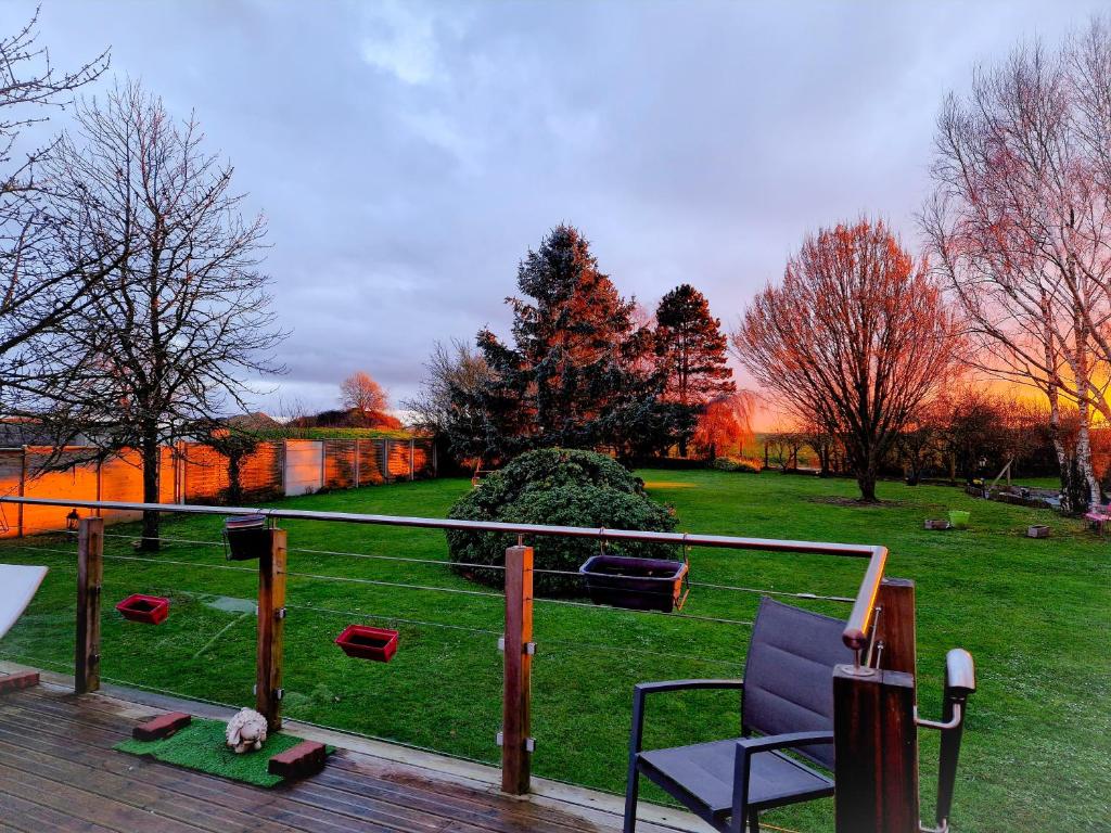 una terraza con una silla y un campo de hierba en Leira 