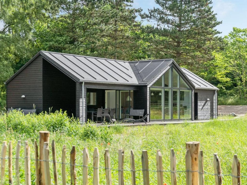 ein schwarzes Haus mit einem Metalldach in der Unterkunft Holiday Home Ella - 1-2km to the inlet in Sealand by Interhome in Rørvig