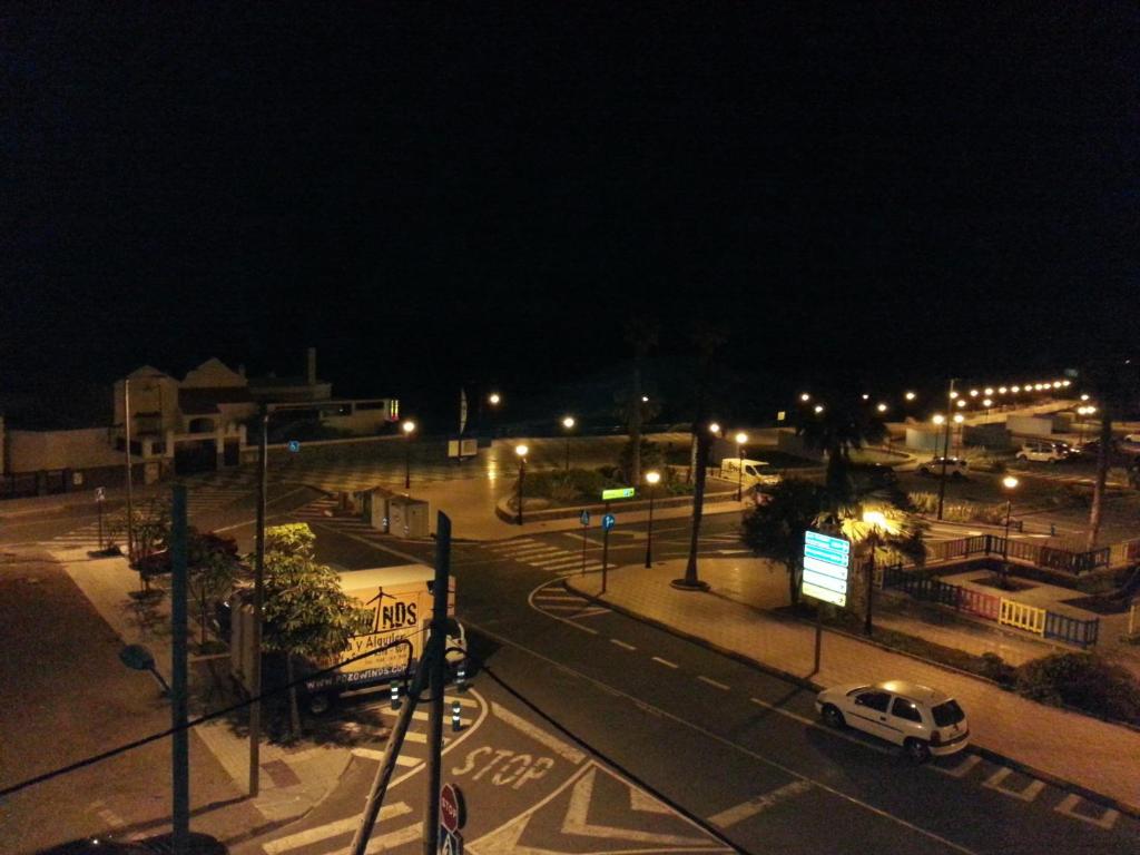 una calle de la ciudad por la noche con un coche en la carretera en Pozo Izquierdo Homelidays, en Pozo Izquierdo