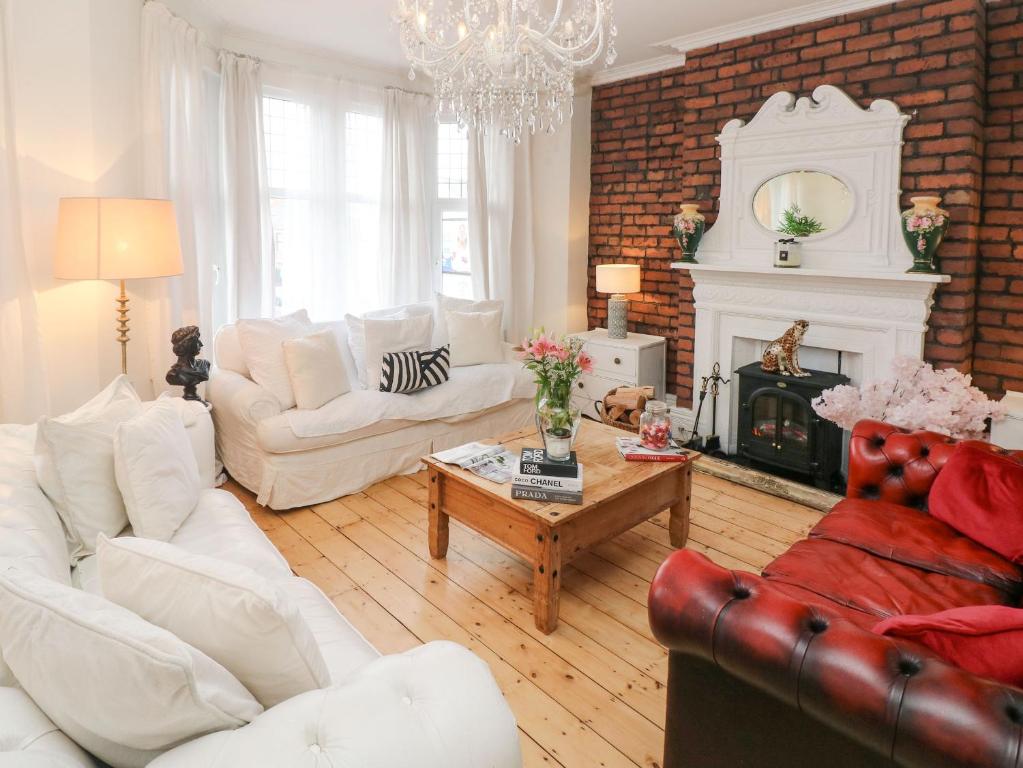 uma sala de estar com mobiliário branco e uma lareira em Stunning Large Victorian Townhouse em Cardiff