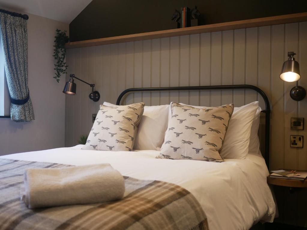 a bedroom with a bed with white sheets and pillows at Waggon and Horses, Eaton, Congleton in Eaton