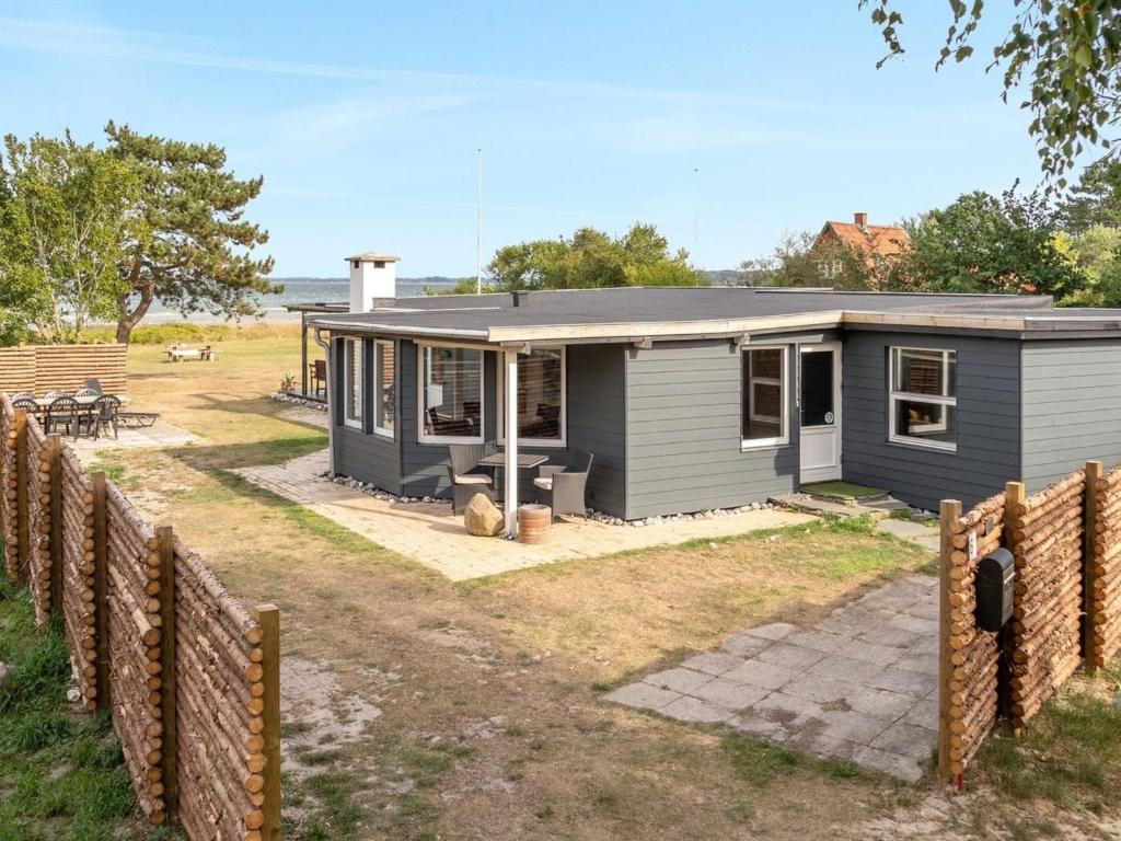 ein blaues Haus mit einem Zaun davor in der Unterkunft Holiday Home Sigurd - 20m from the sea in Funen by Interhome in Middelfart