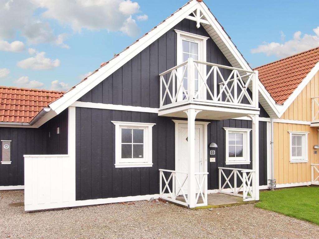 ein schwarzes und weißes Haus mit einem weißen in der Unterkunft Holiday Home Arwin - 250m from the sea in Funen by Interhome in Bro