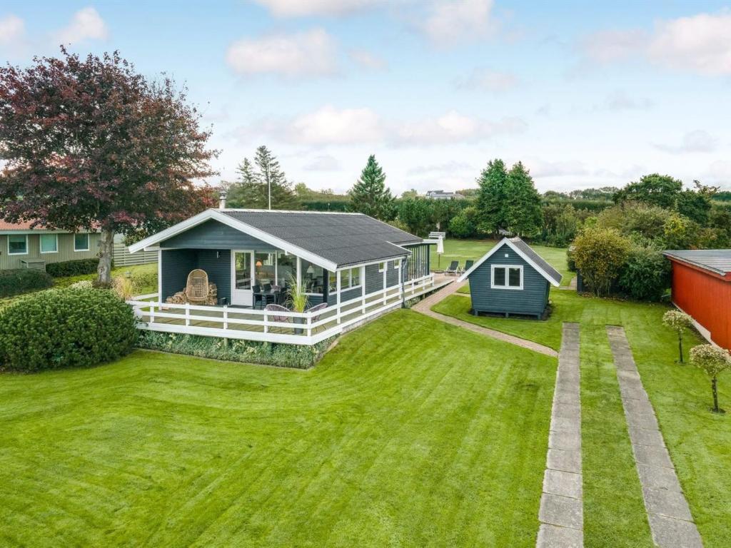 une maison avec une grande cour et un hangar dans l'établissement Holiday Home Fita - 300m from the sea in Funen by Interhome, à Asperup