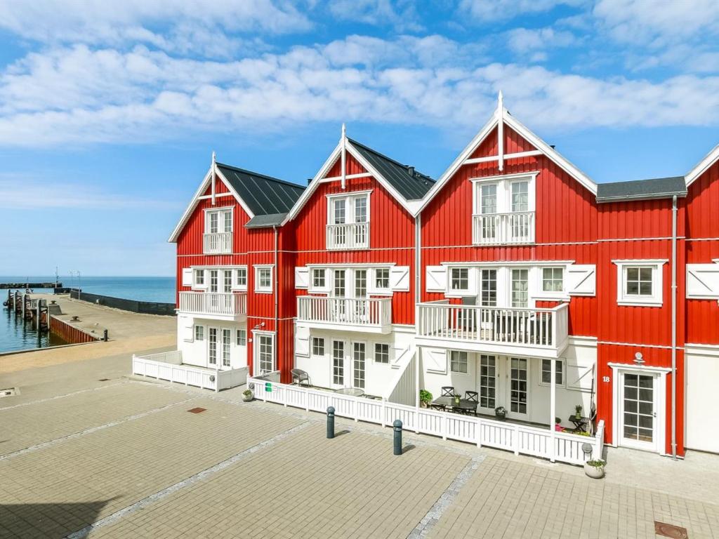 a red building with white windows and a pier at Apartment Terina - 5m from the sea in Funen by Interhome in Bagenkop
