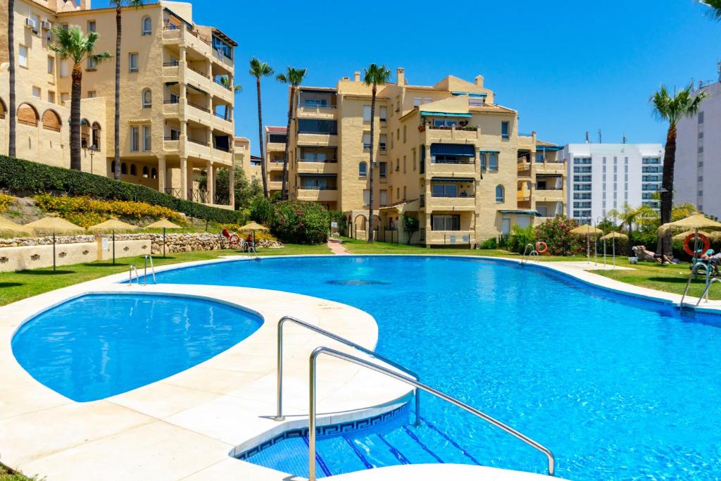 una gran piscina frente a algunos edificios de apartamentos en Lovely flat in Casinomar - Torrequebrada Ref 114, en Benalmádena