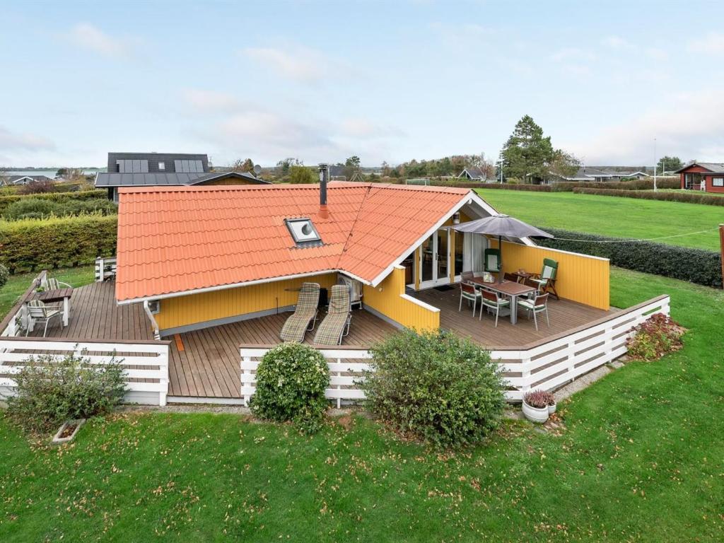 a house with an orange roof and a deck at Holiday Home Hjalmine - 250m from the sea in Funen by Interhome in Assens