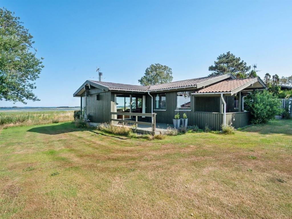 ein kleines grünes Haus mit einem großen Hof in der Unterkunft Holiday Home Nnykka - 100m from the sea in Funen by Interhome in Bøjden