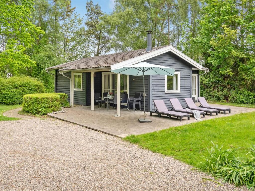 een klein blauw huisje met stoelen en een parasol bij Holiday Home Felisa - 300m from the sea by Interhome in Humble