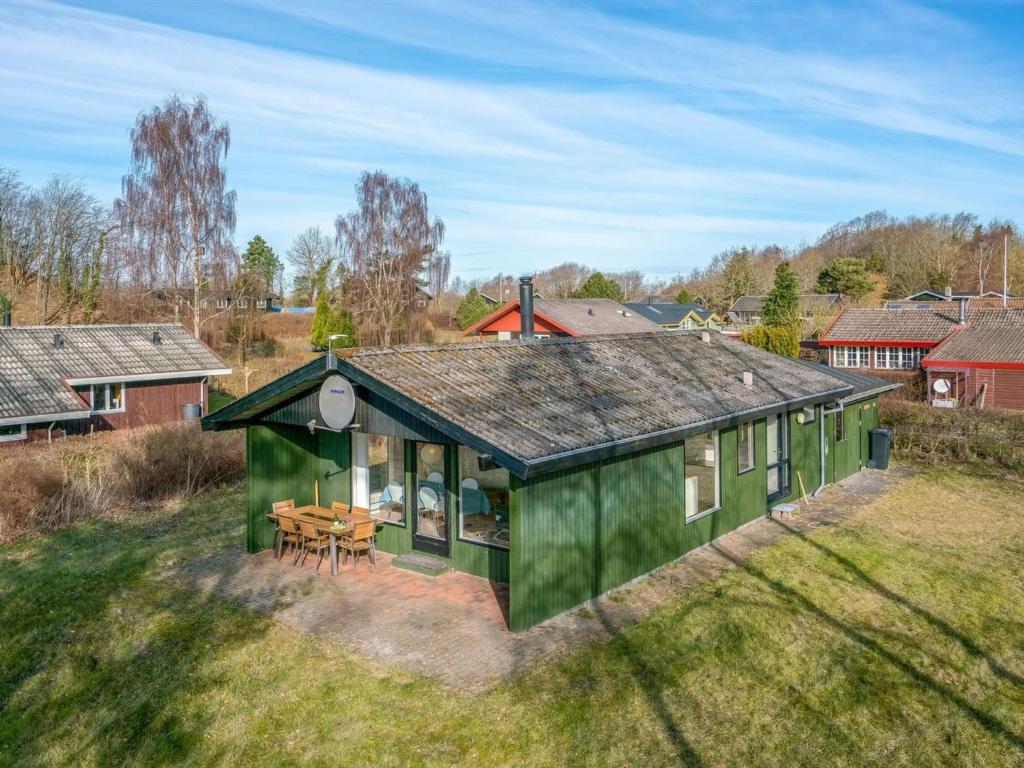 een uitzicht over een groen huis op een veld bij Holiday Home Kalle - 400m from the sea in Funen by Interhome in Hårby