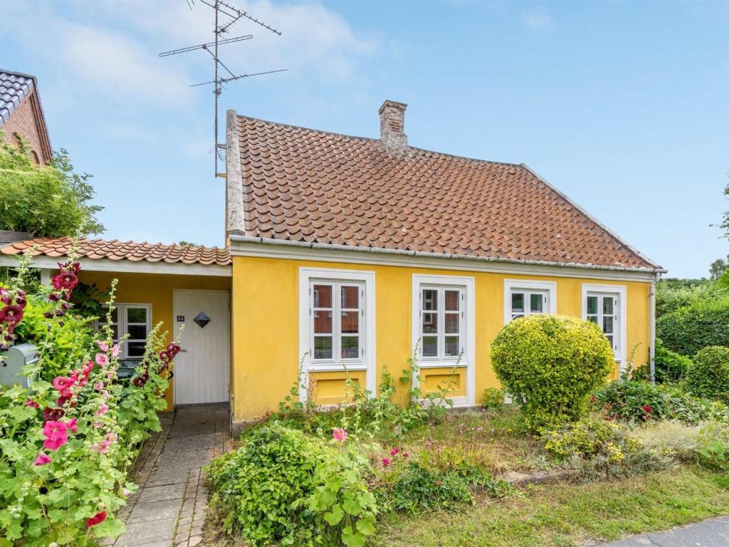 a yellow house with a red roof at Holiday Home Gytta - 1km from the sea in Funen by Interhome in Tranekær