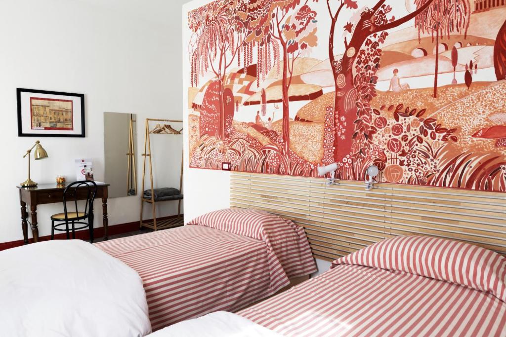 1 dormitorio con 2 camas y un cuadro en la pared en CASABONA1910 bed&breakfast en Vercelli