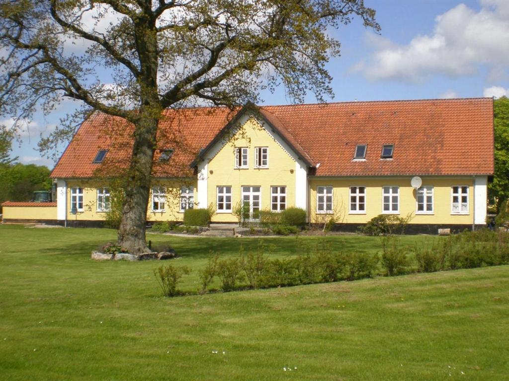 una gran casa amarilla con un árbol en el patio en Apartment Thia - 4km to the inlet in SE Jutland by Interhome en Åbenrå
