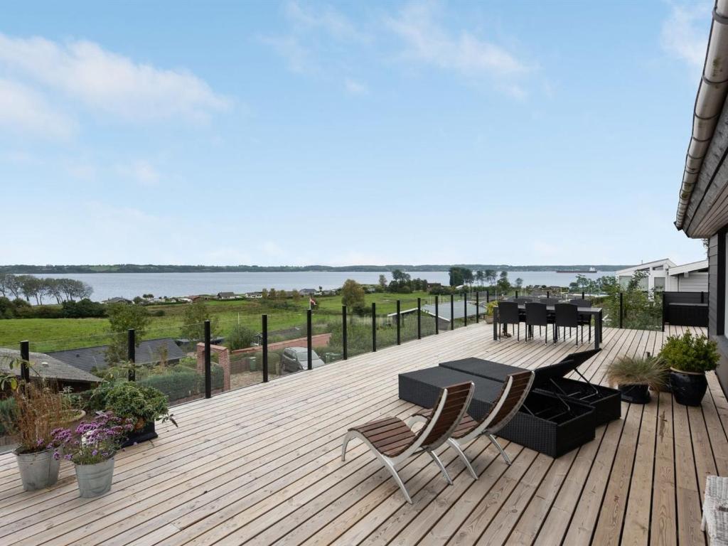 una terraza de madera con mesa y sillas. en Holiday Home Karli - 330m to the inlet in SE Jutland by Interhome en Åbenrå