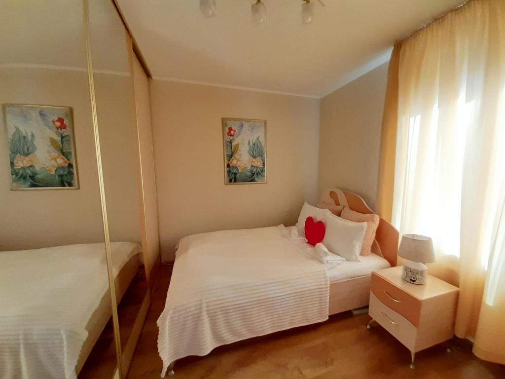 a bedroom with two beds and a mirror at Apartment Central Park in Daugavpils