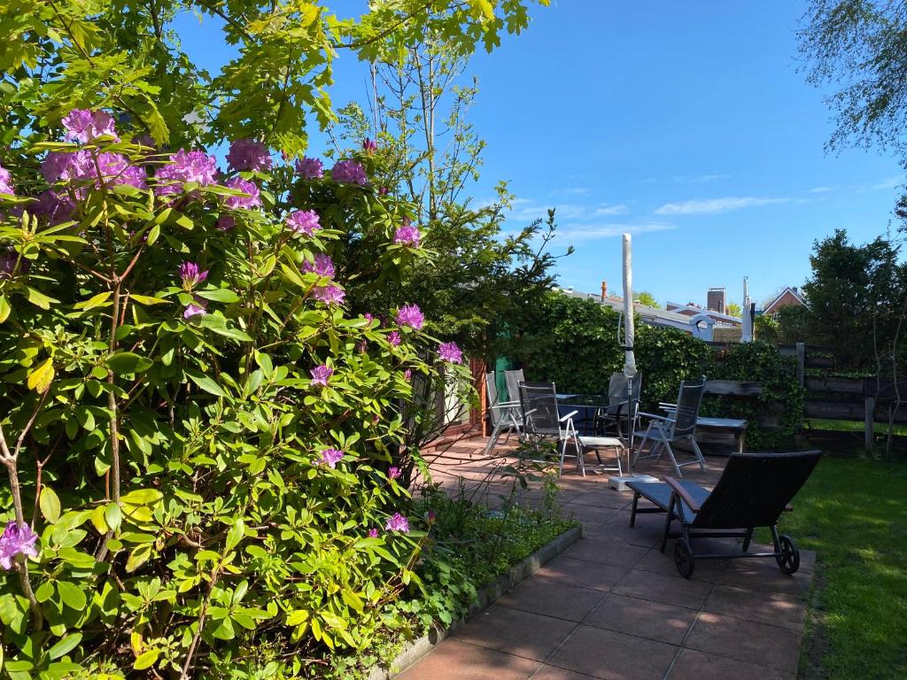 a garden with chairs and flowers on a patio at Ferienhaus Lammertshörn Bensersiel in Bensersiel