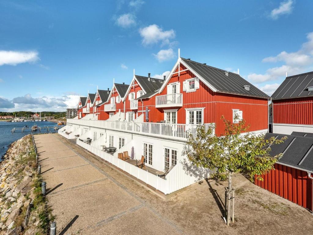 Apartment Joar - 5m to the inlet in SE Jutland by Interhome في جراستين: صف من المباني الحمراء بجانب تجمع للمياه
