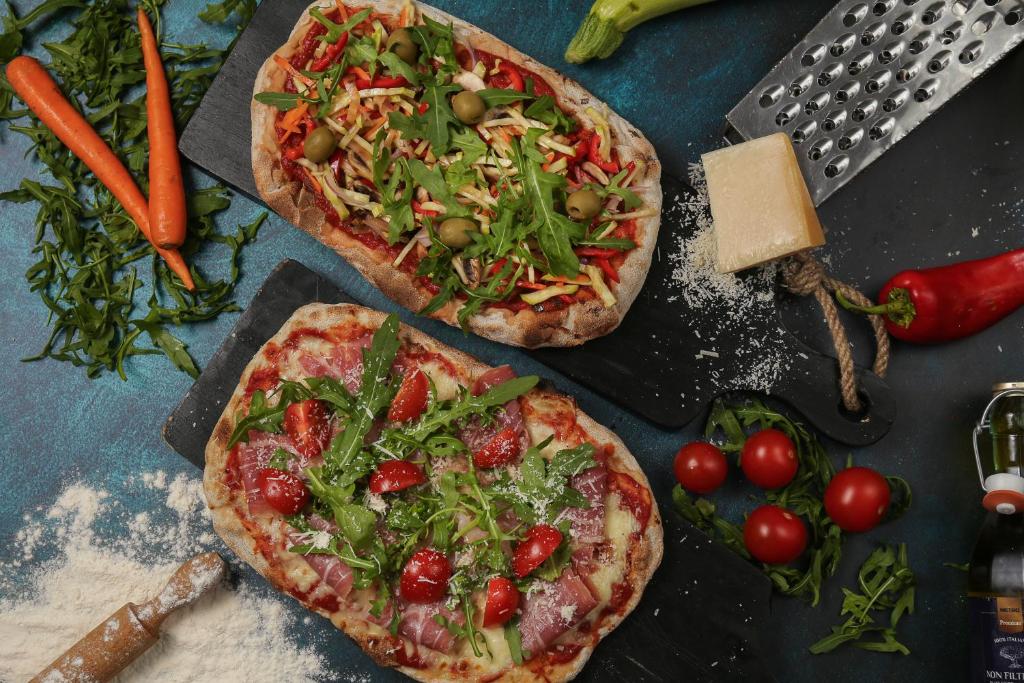 two pizzas sitting on top of a table with vegetables at Hotel Srbija Garden-FREE PARKING in Belgrade
