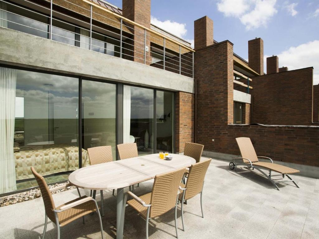 a table and chairs on a patio in front of a building at Apartment Dilruba - 2-4km from the sea in Western Jutland by Interhome in Havneby