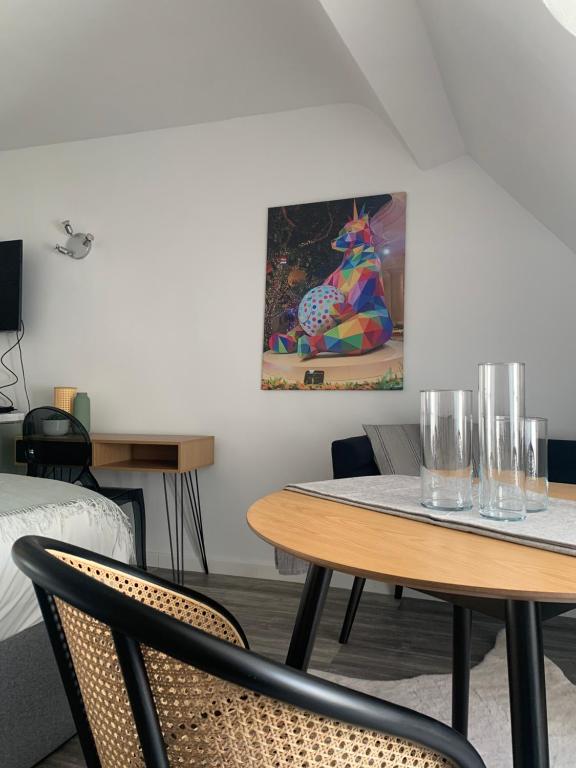una habitación con 2 mesas y sillas y una pintura en appartement catimini, en Dijon