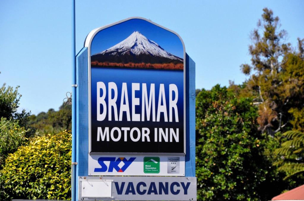 a sign for a motor inn with a mountain on it at Braemar Motor Inn in New Plymouth