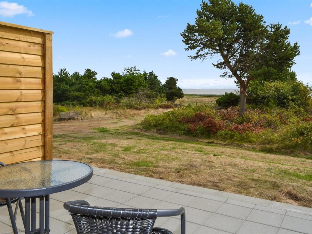 eine Terrasse mit einem Tisch, Stühlen und einem Baum in der Unterkunft Apartment Baltser - 5km from the sea in Western Jutland by Interhome in Kongsmark
