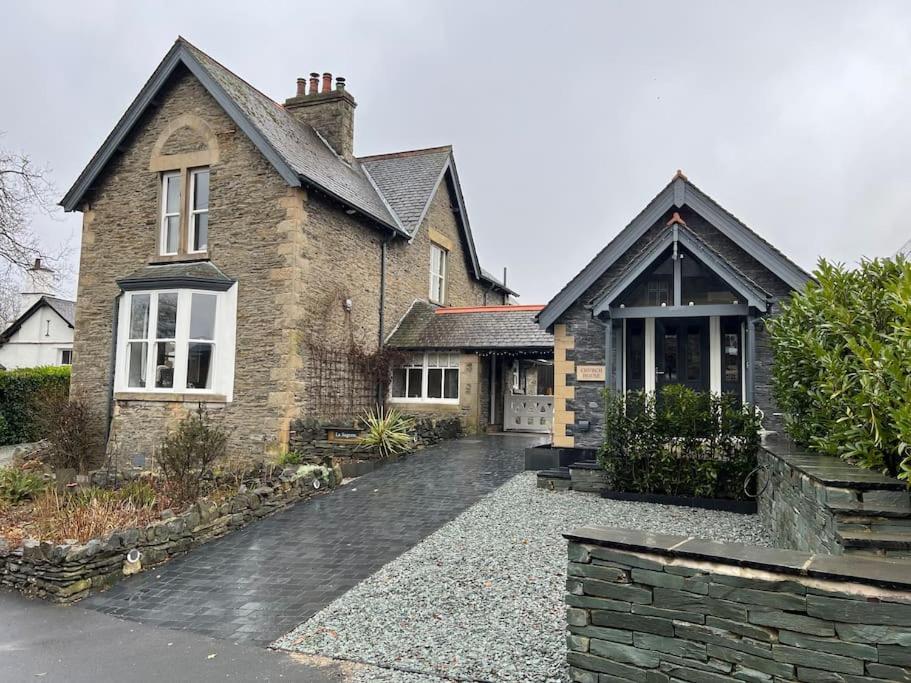 a brick house with a driveway in front of it at La Sagesse in Windermere