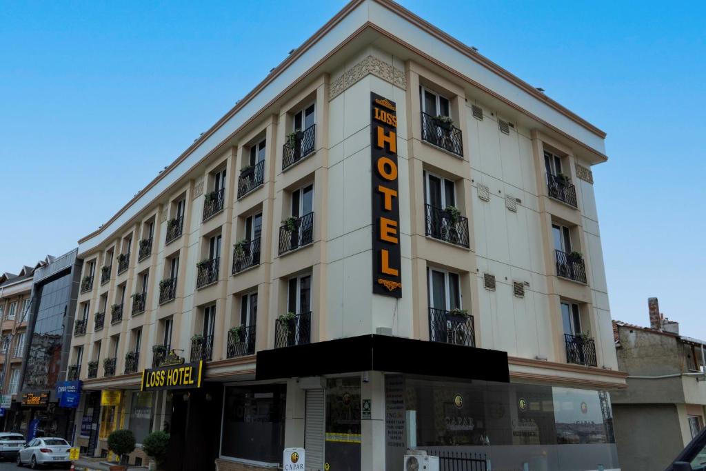 un gran edificio blanco con un cartel de hotel en Loss Hotel, en Beylikduzu