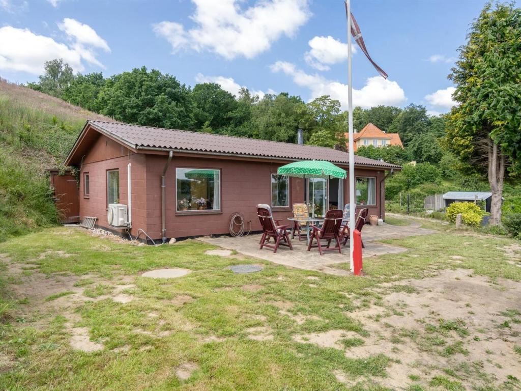 une petite maison avec une table et des chaises dans une cour dans l'établissement Holiday Home Launo - 150m to the inlet in SE Jutland by Interhome, à Børkop