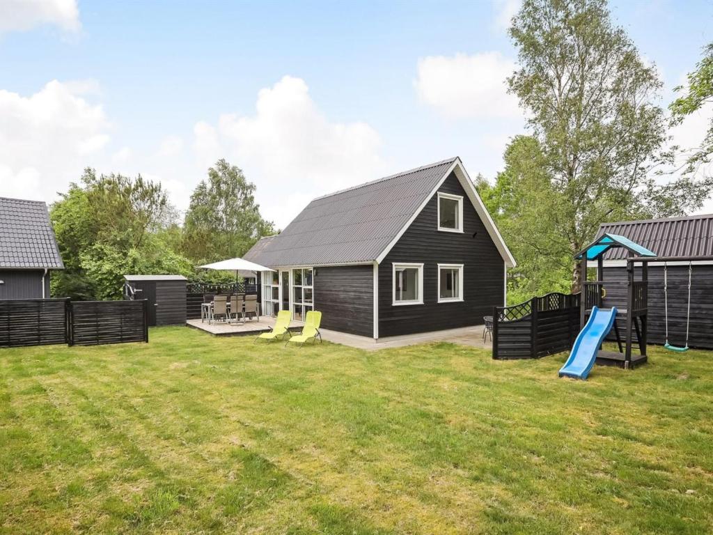 uma casa com um parque infantil no quintal em Holiday Home Vilhelm in SE Jutland by Interhome em Give