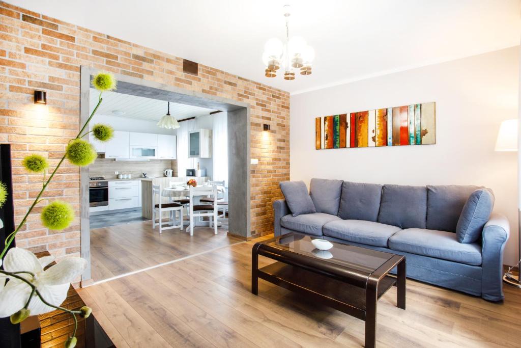 a living room with a blue couch and a brick wall at House Stepic 