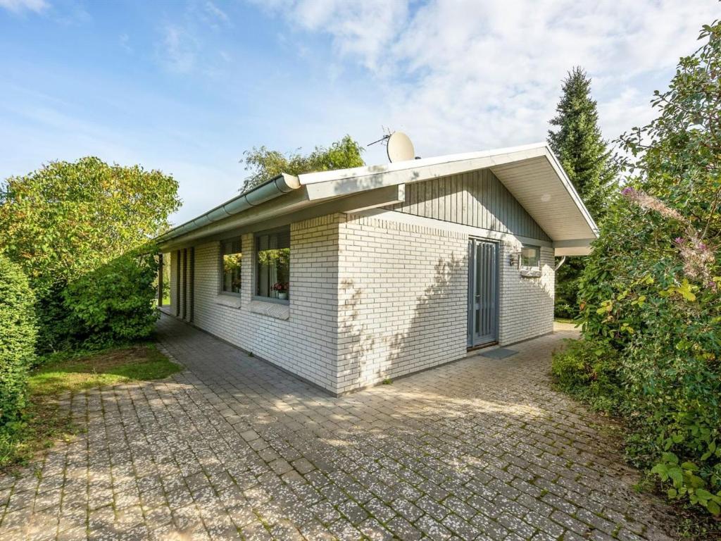 a small white house with a brick driveway at Holiday Home Freding - 250m to the inlet in SE Jutland by Interhome in Børkop
