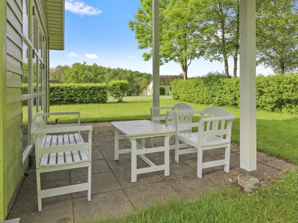 two white chairs and a table on a porch at Holiday Home Terese - 45km from the sea in Western Jutland by Interhome in Grindsted