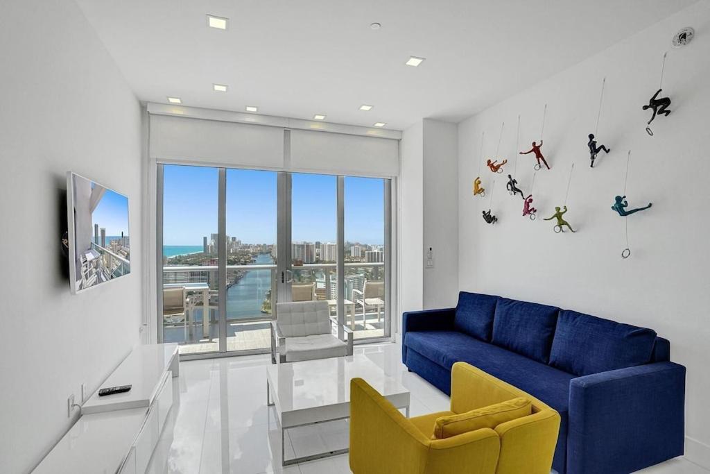 a living room with a blue couch and a yellow chair at Modern Penthouse condo with 2 story private terrace in Hollywood
