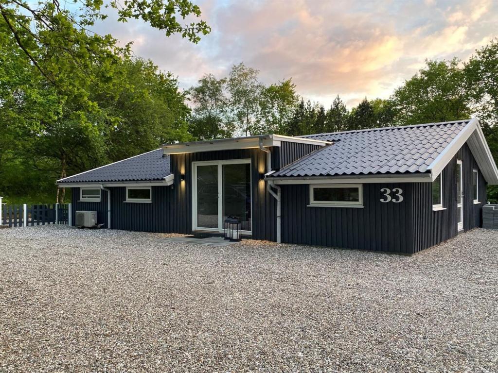 a black house with a gravel driveway at Holiday Home Hariette by Interhome in Give