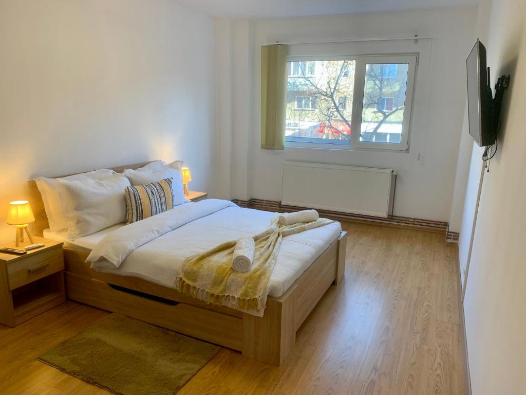 1 dormitorio con 1 cama grande y ventana en JAD - Family Apartments - Zorilor en Brasov