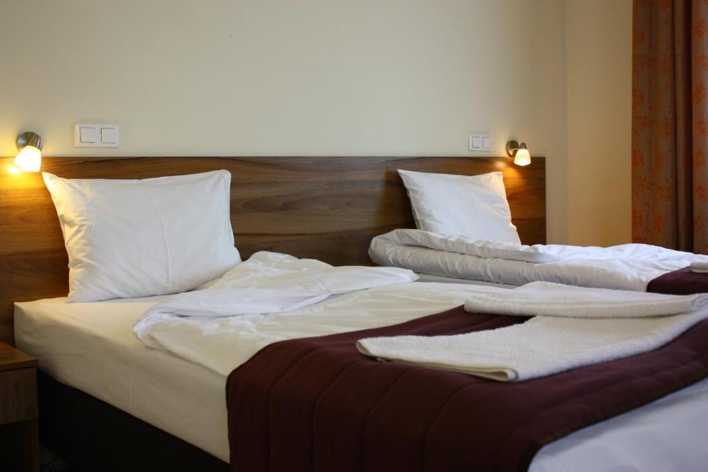 two beds in a hotel room with towels on them at Hotel Czerniewski in Warsaw