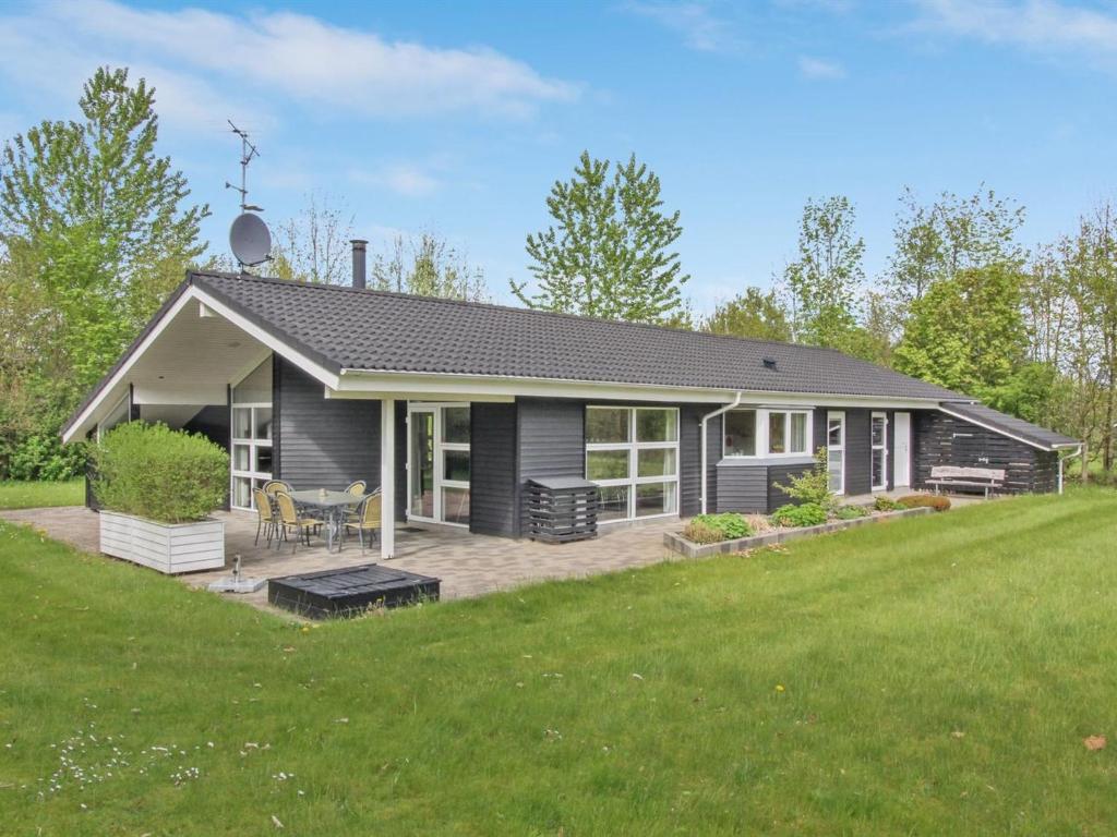 une maison avec une terrasse et une pelouse dans l'établissement Holiday Home Yorrit - 500m to the inlet in The Liim Fiord by Interhome, à Højslev